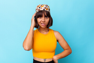 Young mixed race woman isolated on blue background being shocked, she has remembered important meeting.