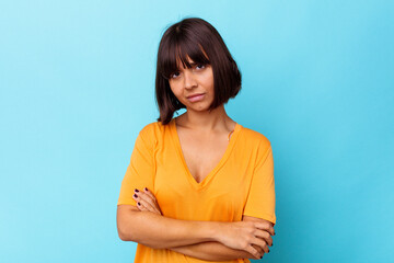 Obraz premium Young mixed race woman isolated on blue background suspicious, uncertain, examining you.