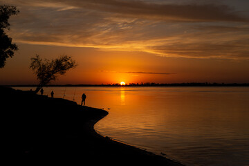 atardecer a la orilla del río pescando