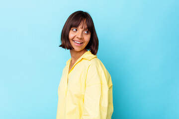 Fototapeta premium Young mixed race woman isolated on blue background confident keeping hands on hips.