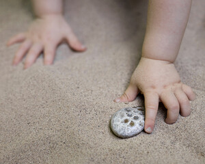 michigan Baby kid child toddler finds grabs petoskey stone on beach summer lake michigan vacation