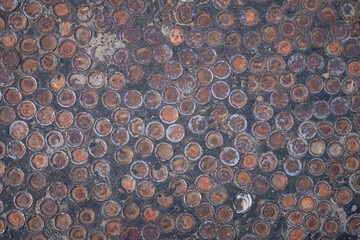 Lot of rust circle aluminum on black background, flattened aluminum plugs in asphalt, Abstract background and circles