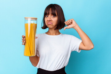 Young mixed race woman holding pasta jar isolated on blue background feels proud and self confident, example to follow.