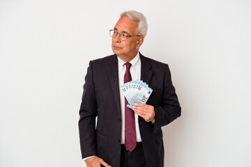 Senior american business man holding bills isolated on white background confused, feels doubtful and unsure.