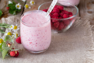 Yogurt with raspberries on wooden table