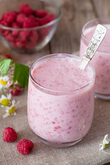 Yogurt with raspberries on wooden table