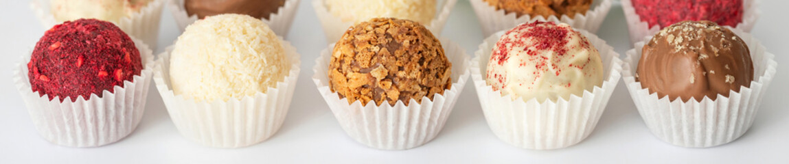 Candy banner. Homemade truffles on a white background close up. Energy balls candies.