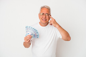 Senior american man holding bill isolated on white background showing a disappointment gesture with...
