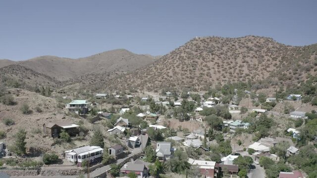 Aerial view of the town of Bisbee in Arizona. This small town is surrounded by mountains and has many building, homes, and trees. 