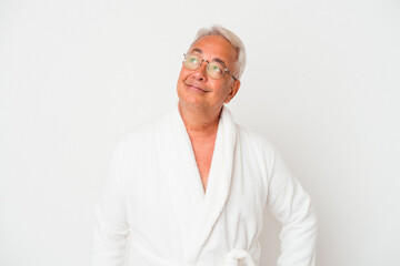 Senior american man wearing bathrobe isolated on white background dreaming of achieving goals and purposes
