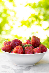 Strawberry in white plate on green background