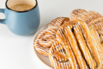 Cinnamon rolls or buns on plate with blue cup of coffee. Classic American or French bakeries. 