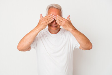 Senior american man isolated on white background afraid covering eyes with hands.