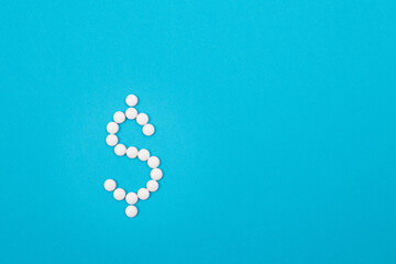 Global Pharmaceutical Industry and Medicine Business - Dollar Symbol Made from White Pills Lying on Blue Background