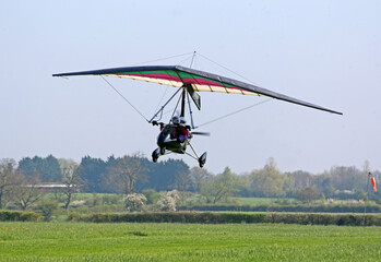 Ultralight airplane taking off from a grass airfield	