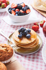 blueberry pancake with marple syrup ON A RED SQUATE TABLECLOTH