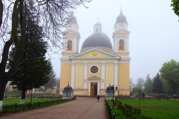 Fototapeta na wymiar Chernivtsi, Ukraine-May 14, 2021:Picturesque foggy landscape view of medieval Cathedral of the Holy Spirit. Spring morning view. Christian Orthodox cathedral