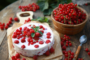 Summer atmosphere. Russian cuisine. Dacha, nature. Cottage cheese pie, cake with fresh berries: red currants and raspberries on an old wooden table. Background image, copy space