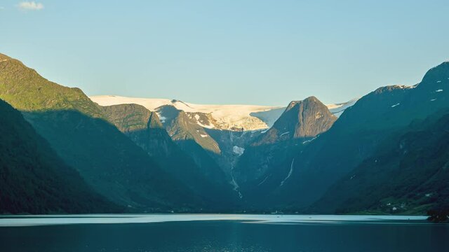 Scenic View Of Briksdalsbreen Glacier Behind Mountain Ridges Surrounding Olden Lake In Norway. - Time Lapse