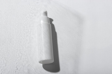 Cosmetic cream or mask in a white tube with hard shadows on a white background. Natural organic care for face and body skin. View from above.