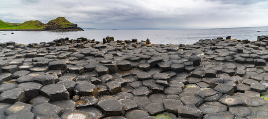 Giant's Causeway basalt rocks pattern in a beautiful summer day, Northern Ireland. The nature hexagon stones result of an ancient volcanic fissure eruption. - obrazy, fototapety, plakaty