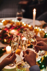 Cheers with champagne. People clink glasses of champagne at the holiday table on New Year's Eve....
