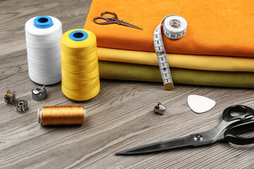 Different sewing supplies and fabric on wooden table