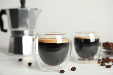 Tasty coffee and beans on white wooden table