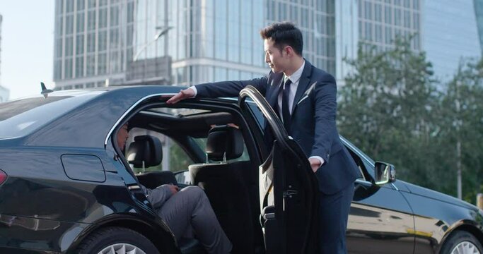 Confident businessman getting out of car,4K