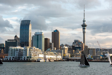 Famous skyline of Auckland Central Business District during sunset, people anjoying the warm summer evening on their sailboats