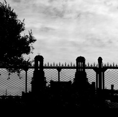 Two old towers over a fence, black and white
