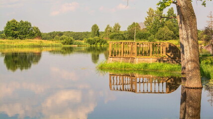 Fototapeta na wymiar Summer landscape with lake and pier on the shore