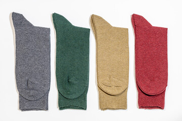 A row of new solid colored socks on a white background. Cotton textile products