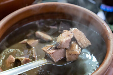Ceramic pot with feijoada, typical Brazilian food. In a restaurant in Brazil