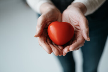 image of a red heart in the palms of a woman.