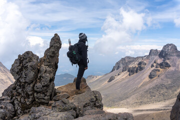 Back view of a hiker with a backpack on top of the Iztaccihuatl volcano