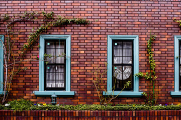 Fototapeta na wymiar Red brick wall with framed windows