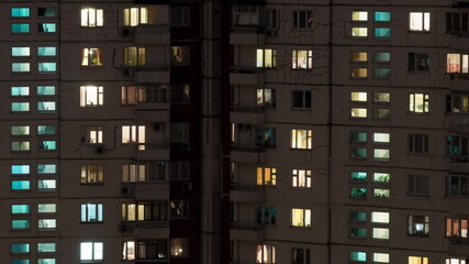 Fototapeta na wymiar Time lapse shot of buildings and lighted windows at night