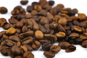 Coffee beans in bulk on a white background. Close-up. Selective focus.