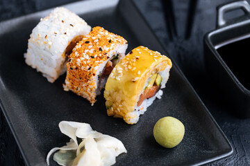 Different sushi rolls on a dark black background