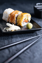 Different sushi rolls on a dark black background