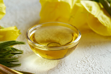 A bottle of evening primrose oil with fresh blooming evening primrose