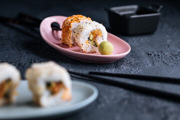 Different sushi rolls on a dark black background