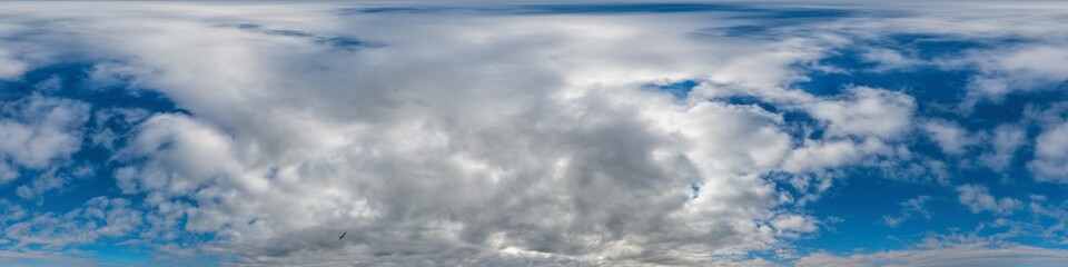 Blue evening sky seamless panorama spherical equirectangular 360 degree view with Cumulus clouds, setting sun. Full zenith for use in 3D graphics, game and aerial drone panoramas as sky replacement.