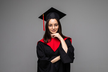 Happy young student with diploma on grey background