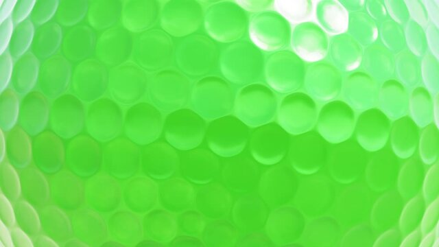 Realistic looping closeup view 3D animation of the spinning green golf ball rendered in UHD as motion background
