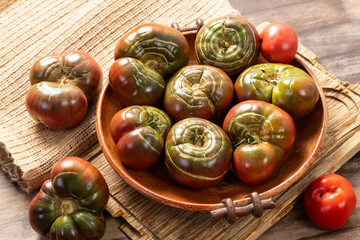 Organic tomatoes in a ceramic bowl. Organic farming or gardening concept.