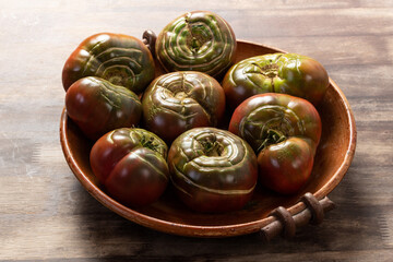 Organic tomatoes in a ceramic bowl. Organic farming or gardening concept.