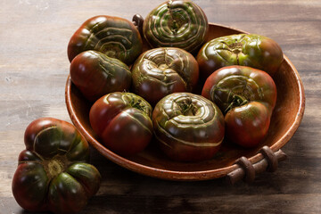 Organic tomatoes in a ceramic bowl. Organic farming or gardening concept.