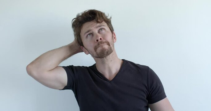 I don't know. Caucasian male is misunderstanding, grabbing head, puzzled and confused. Handsome man in casual t-shirt isolated on white background, at a loss. People lifestyle, human emotions concept
